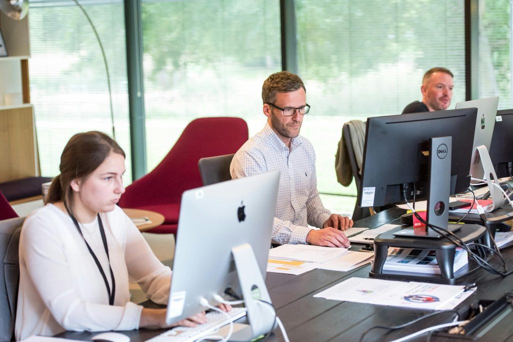 A group of people working on computers at an office